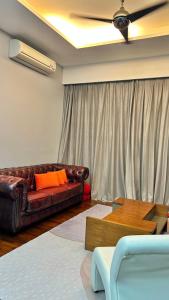 a living room with a leather couch and a table at LUXURY 3BR Penthouse I The Shore Hotel & Residence I Seaview I Poolview I 6-9Pax in Malacca