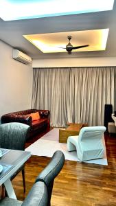 een woonkamer met een plafondventilator en een bank bij LUXURY 3BR Penthouse I The Shore Hotel & Residence I Seaview I Poolview I 6-9Pax in Melaka