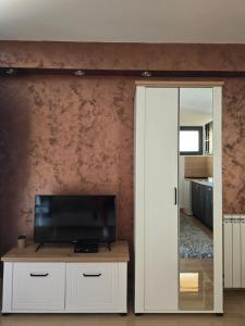 a living room with a tv and a mirror at ARIJA studio apartment in Žabljak