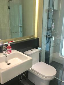 a bathroom with a sink and a toilet and a mirror at LUXURY 3BR Penthouse I The Shore Hotel & Residence I Seaview I Poolview I 6-9Pax in Melaka