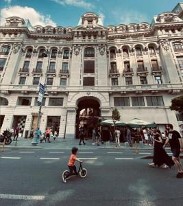 a little boy riding a scooter in front of a building at ROUGE Studio in Bucharest in Bucharest