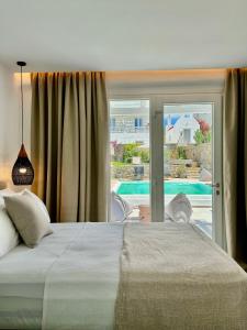 a bedroom with a bed and a view of a pool at Sofos Suites Mykonos in Mikonos