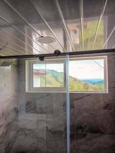 ein Bad mit einer Glasdusche und einem Fenster in der Unterkunft Finca La Macarena by Welttisch in Génova
