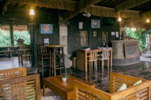 a restaurant with chairs and tables and a bar at Kubuku Ubud Villas in Ubud