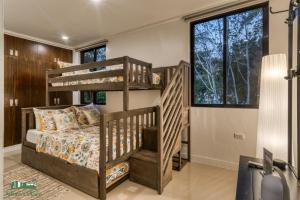 Adora's Place في كورون: غرفة نوم مع سرير بطابقين ونوافذ كبيرة