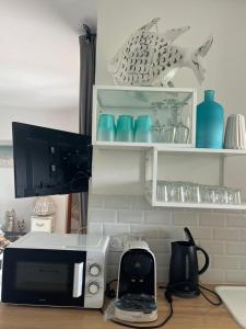 um balcão de cozinha com um micro-ondas e alguns pratos azuis em Favone Mini Villa Playa del Oro em Favone