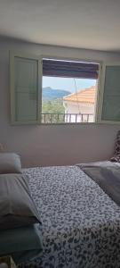 - une chambre avec un lit et une grande fenêtre dans l'établissement La Estrellita, à Iznájar