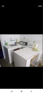 uma cozinha branca com um lavatório e um micro-ondas em Au Havre de Paix em Niamey