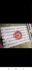 a white bench with a red flower on it at Au Havre de Paix in Niamey