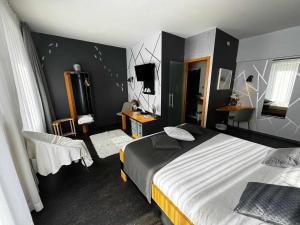 a bedroom with a large bed and a television at Hotel Val de Poix in Saint-Hubert