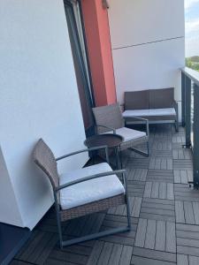 2 sillas y una mesa en el balcón en Saules apartamentai, free parking, en Klaipėda