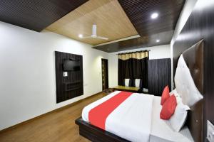 una camera con un grande letto e una televisione di Goroomgo Hotel Dalhousie Grand Banikhet Near Mata Jawala Temple - Luxury Stay - Excellent Service - Parking Facilities a Banikhet