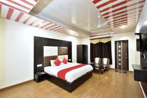 BanikhetにあるGoroomgo Hotel Dalhousie Grand Banikhet Near Mata Jawala Temple - Luxury Stay - Excellent Service - Parking Facilitiesのベッドルーム(大型ベッド1台、テレビ付)
