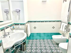 uma casa de banho com 2 lavatórios e um espelho em Na Stanza in centro em Ravello