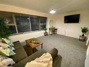 RavensworthにあるSpacious 2 Bed with sofabed in the Centre of Low Fell, Gateshead!のリビングルーム(ソファ、テーブル付)