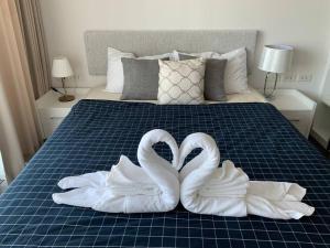 two swansuitsrendered to look like they are kissing on a bed at Infinity Pool at Pattaya Posh in North Pattaya +12 photos