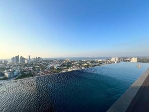 a view of a pool with a city in the background at Infinity Pool at Pattaya Posh in Pattaya North