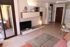 a living room with a flat screen tv on a wall at Spacious apartment with large private garden in Palm Mar in Palm-Mar