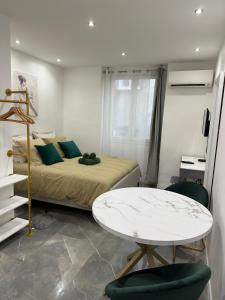 a bedroom with a bed and a table and chairs at La Chic Opéra NETFLIX/WIFI in Marseille