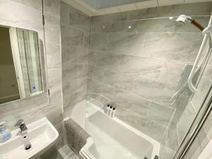 bagno con vasca bianca e lavandino di Spacious 2 Bed Private Apartment with sofabed in the Centre of Low Fell, Gateshead! a Ravensworth