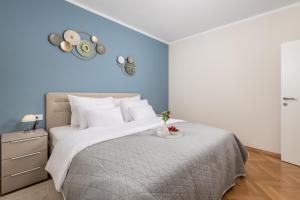 een slaapkamer met een groot bed met een blauwe muur bij Apartment Marina -1st row to the sea in Opatija