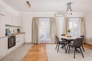 een keuken en eetkamer met een tafel en stoelen bij Apartment Marina -1st row to the sea in Opatija