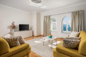 een woonkamer met 2 banken en een tv bij Apartment Marina -1st row to the sea in Opatija