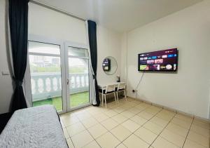 a bedroom with a large window and a tv on the wall at STA Homes Dubai in Dubai