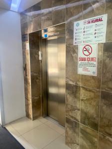 een lift in een gebouw met een bord aan de muur bij ARGEUS PRESTİJ in Kayseri