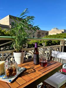 a wooden table with a bottle of wine on a balcony at La Casetta di Romeo in Trapani