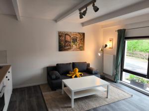 a living room with a couch and a table at Ferienwohnung am Mühlbach in Klipphausen +2 photos