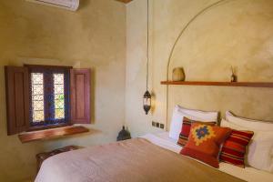 sypialnia z łóżkiem i oknem w obiekcie Lina Boutique Villas and Spa w Kuta Lombok