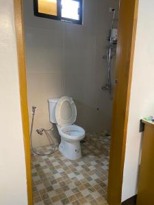 a bathroom with a white toilet in a room at Villa Malinao Oceanview Resort - Deluxe bungalow in Burgos