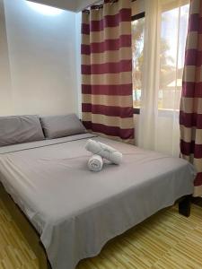 - un lit avec 2 serviettes dans une chambre dans l'établissement Villa Malinao Oceanview Resort - Deluxe bungalow, à Burgos