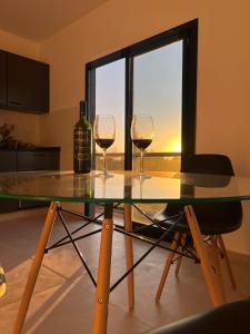 dos copas de vino sentadas en una mesa de cristal en una cocina en Alka hermoso y cómodo departamento en Morón
