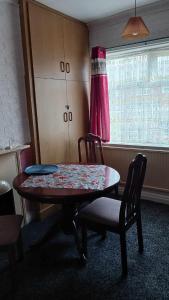 um quarto com uma mesa e cadeiras e uma janela em Amarillys Guest House em Preston