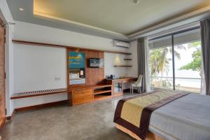 Schlafzimmer mit einem Bett, einem Schreibtisch und einem Fenster in der Unterkunft Golden Pearl Tangalle Beach New in Hambantota