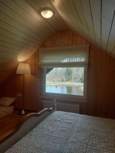 sypialnia z łóżkiem i oknem w obiekcie Kuuse metsamaja 