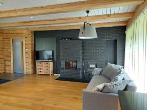 a living room with a couch and a fireplace at Kuuse metsamaja in Saaremaa