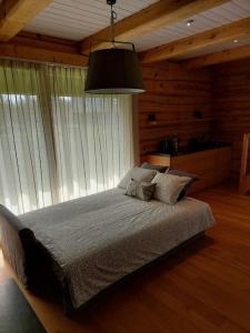 sypialnia z dużym łóżkiem i dużym oknem w obiekcie Kuuse metsamaja 