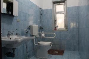 y baño con aseo y lavamanos. en Villa Nastasi, en San Pier Niceto