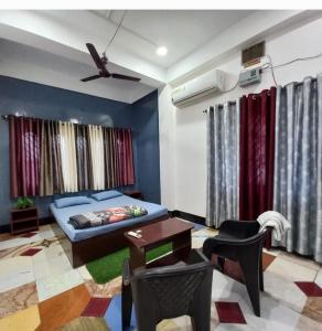 a bedroom with a bed and a table and chairs at Riverbank Guest House With Restaurant & self cooking facility in Guwahati