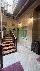 a large room with stairs and a green wall at Sazeli Boutique Hotel in Baku