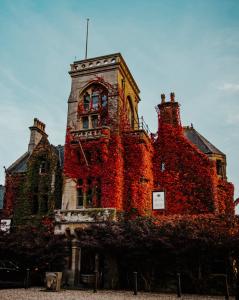 an old building is covered in red ivy at The Rudloe Arms Hotel Marco Pierre White Nr Bath in Corsham