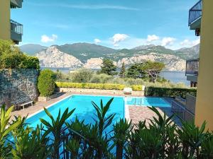 a swimming pool with a view of the water and mountains at Andreis Apartments in Malcesine