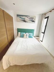 a bedroom with a large white bed with blue pillows at CASA LORENZO in the center in Playa Blanca