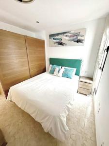 a bedroom with a bed with white sheets and blue pillows at CASA LORENZO in the center in Playa Blanca