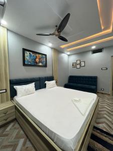 Hotel dwarka palace في Darbhanga: سرير كبير في غرفة بها مروحة سقف