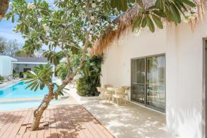 邦勞的住宿－奧那海明珠度假村，一座别墅,设有游泳池和棕榈树