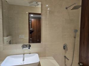 ein Bad mit einem Waschbecken und einer Dusche mit einem Spiegel in der Unterkunft MBS BANQUETS in Amritsar